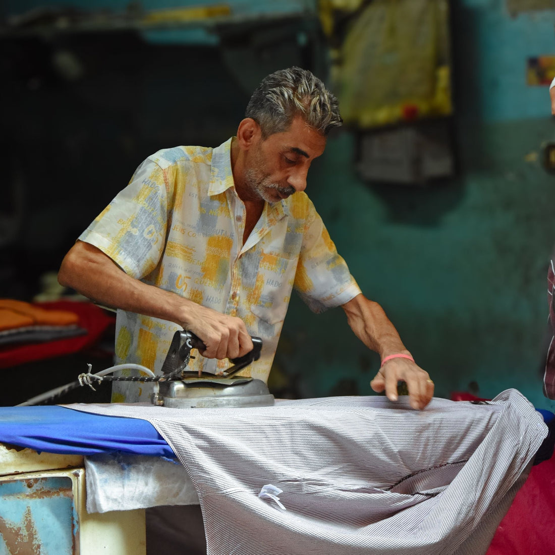 man ironing thobes