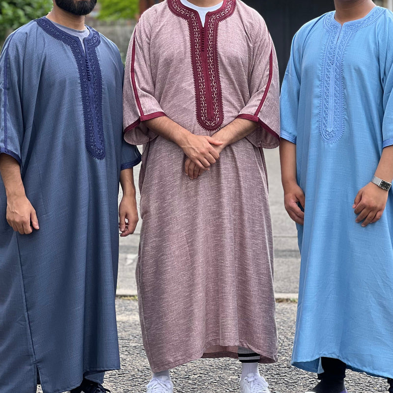 Three men wearing Moroccan gandouras with short or three-quarter sleeves and embroidered chest panels