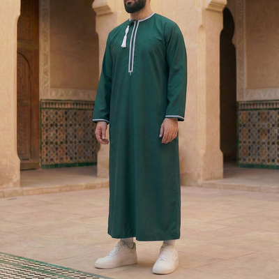 man wearing emerald green omani thobe with detachable tassel