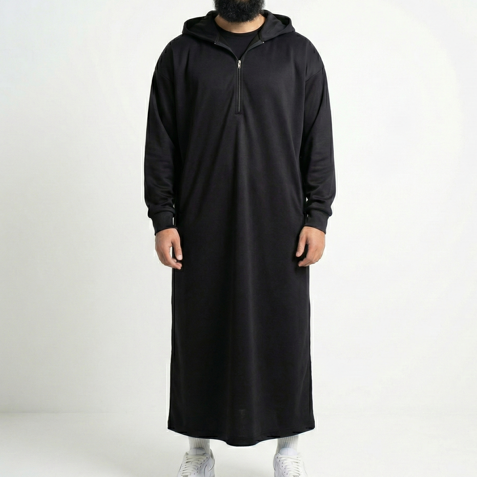 Person wearing a long black hoodie on a white background