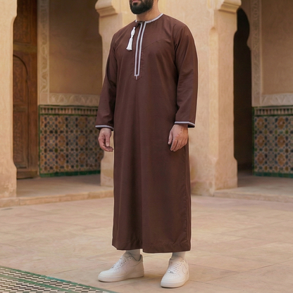 man wearing brown omani thobe with detachable tassel