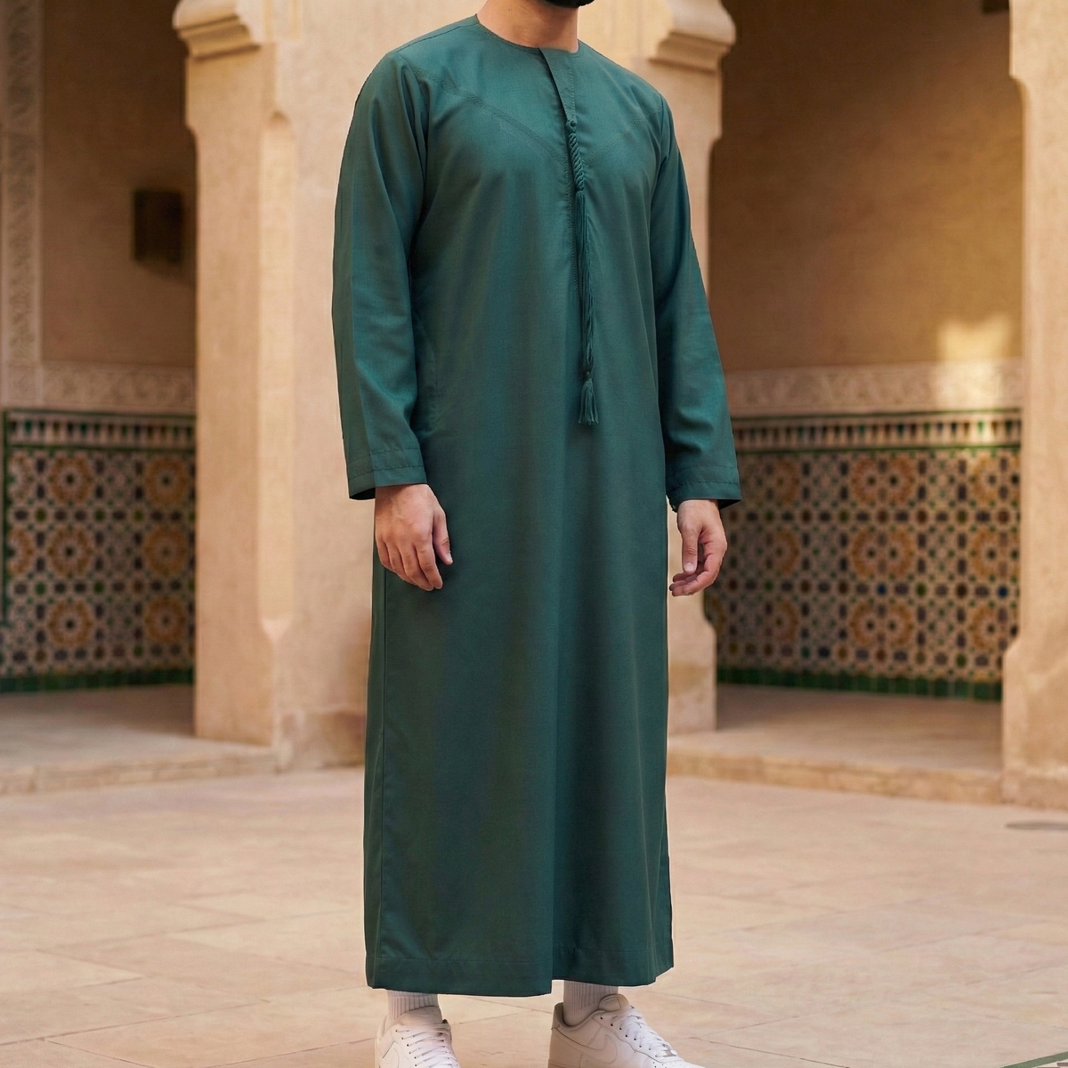 man wearing emerald green emirati thobe with detachable tassel