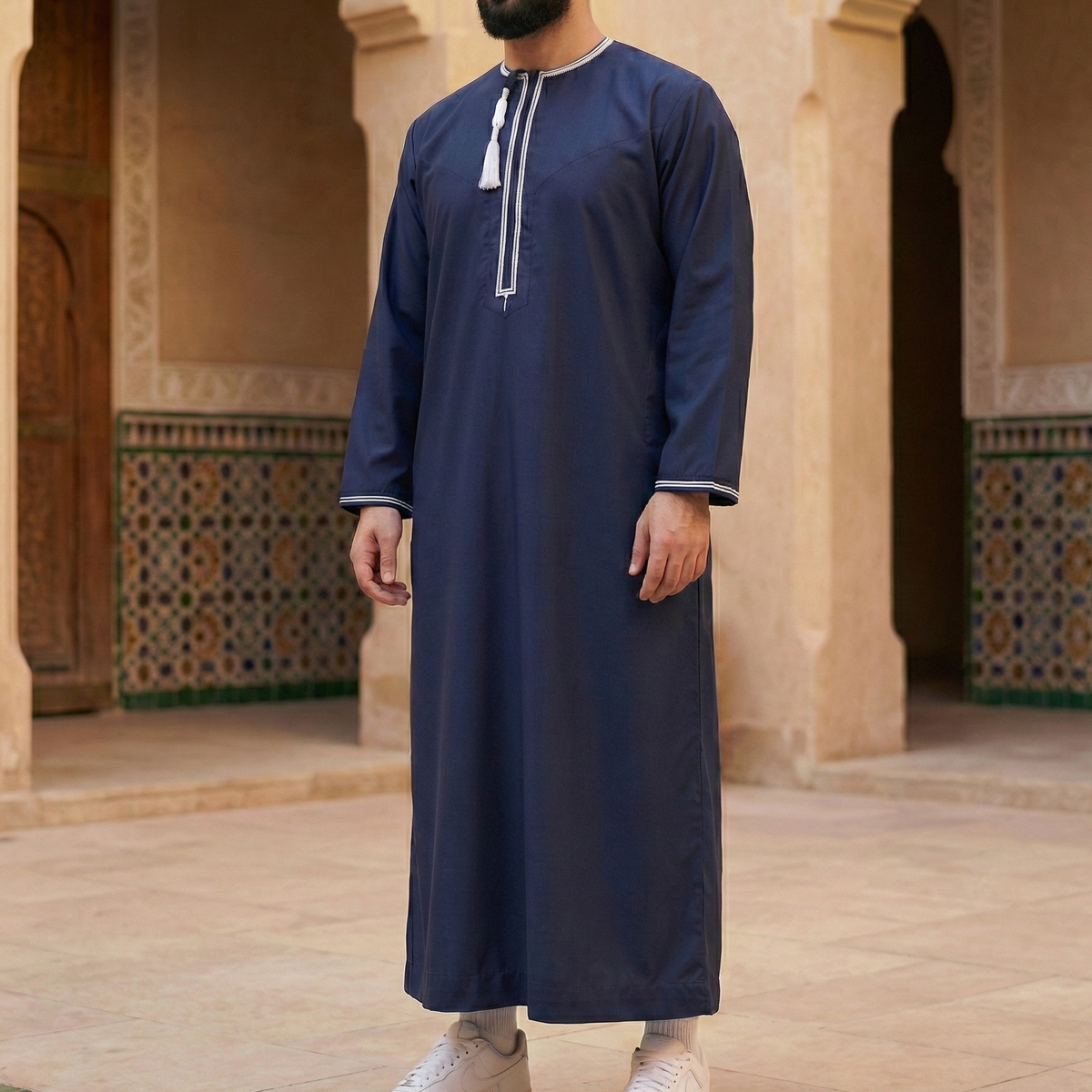 man wearing navy blue omani thobe with detachable tassel